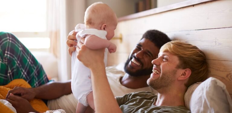 couple-in-bed-holding-up-baby.ashx_.jpeg